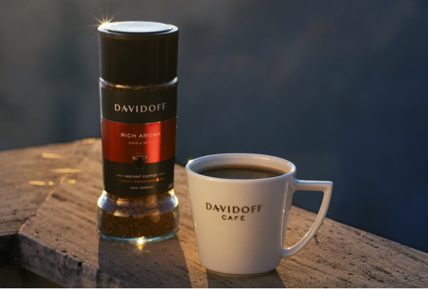 DAVIDOFF coffee canister and mug on a stone surface with a blurred natural background